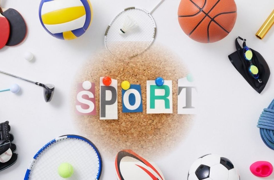 in der Mitte steht Sport, drum herum liegen viele Sportutensilien, wie Bälle, Schläger